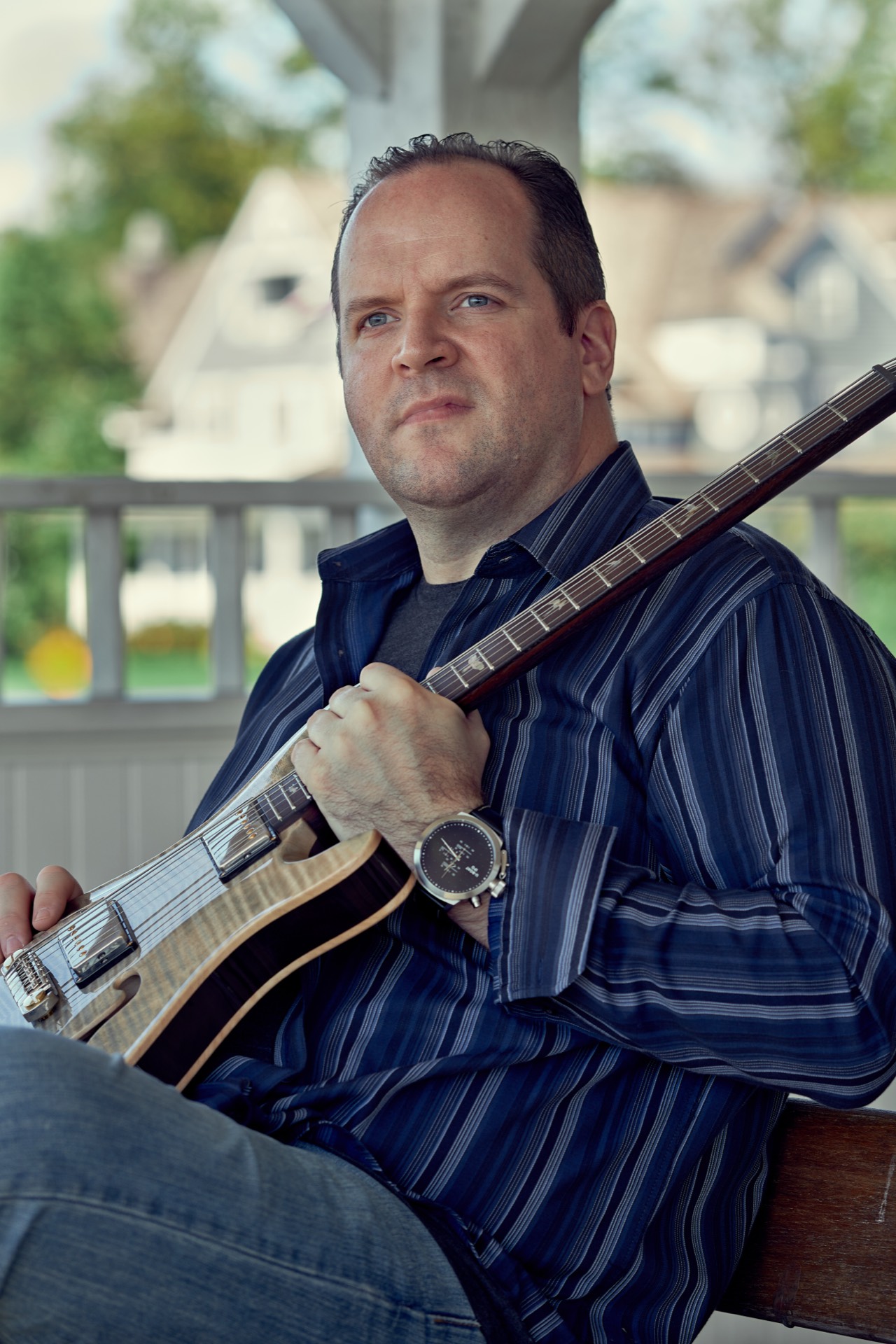 Ron Gilmartin sitting on the porch with his guitar